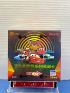 A Disney Cars Hot Box collectible card pack box displayed on a clear stand against a white ribbed wall background. The packaging features Lightning McQueen and other Disney Cars characters with Chinese text.