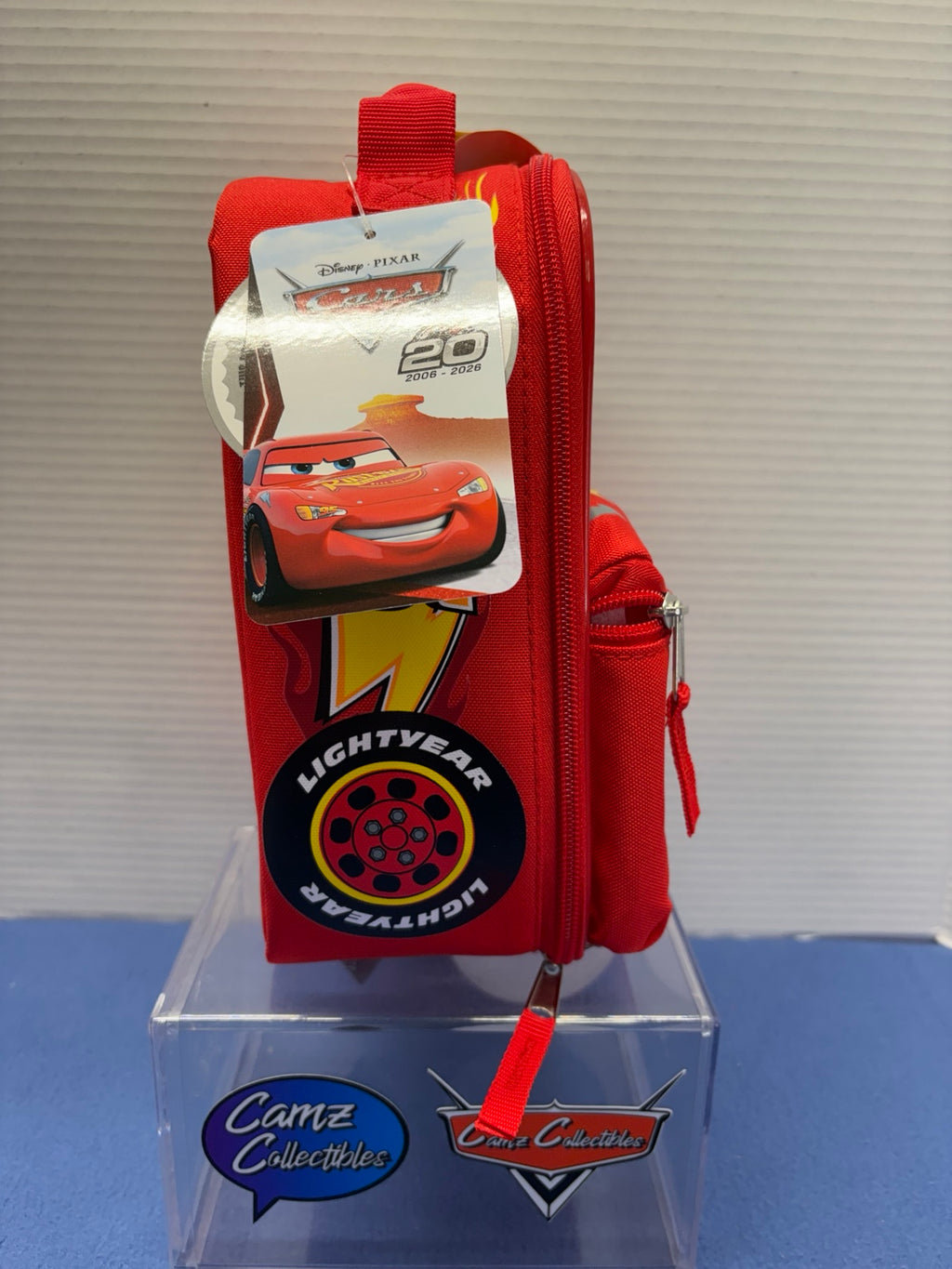 Side of Lightning McQueen lunch box showing zipper and 20th anniversary hangtag