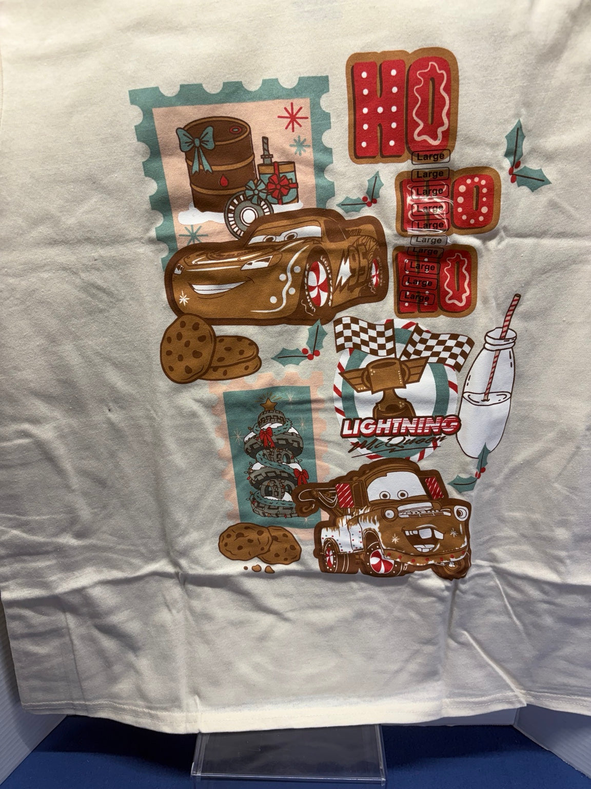 Close-up of Lightning McQueen and Mater holiday PJ shirt graphic with cookies, holly and Ho Ho Ho lettering
