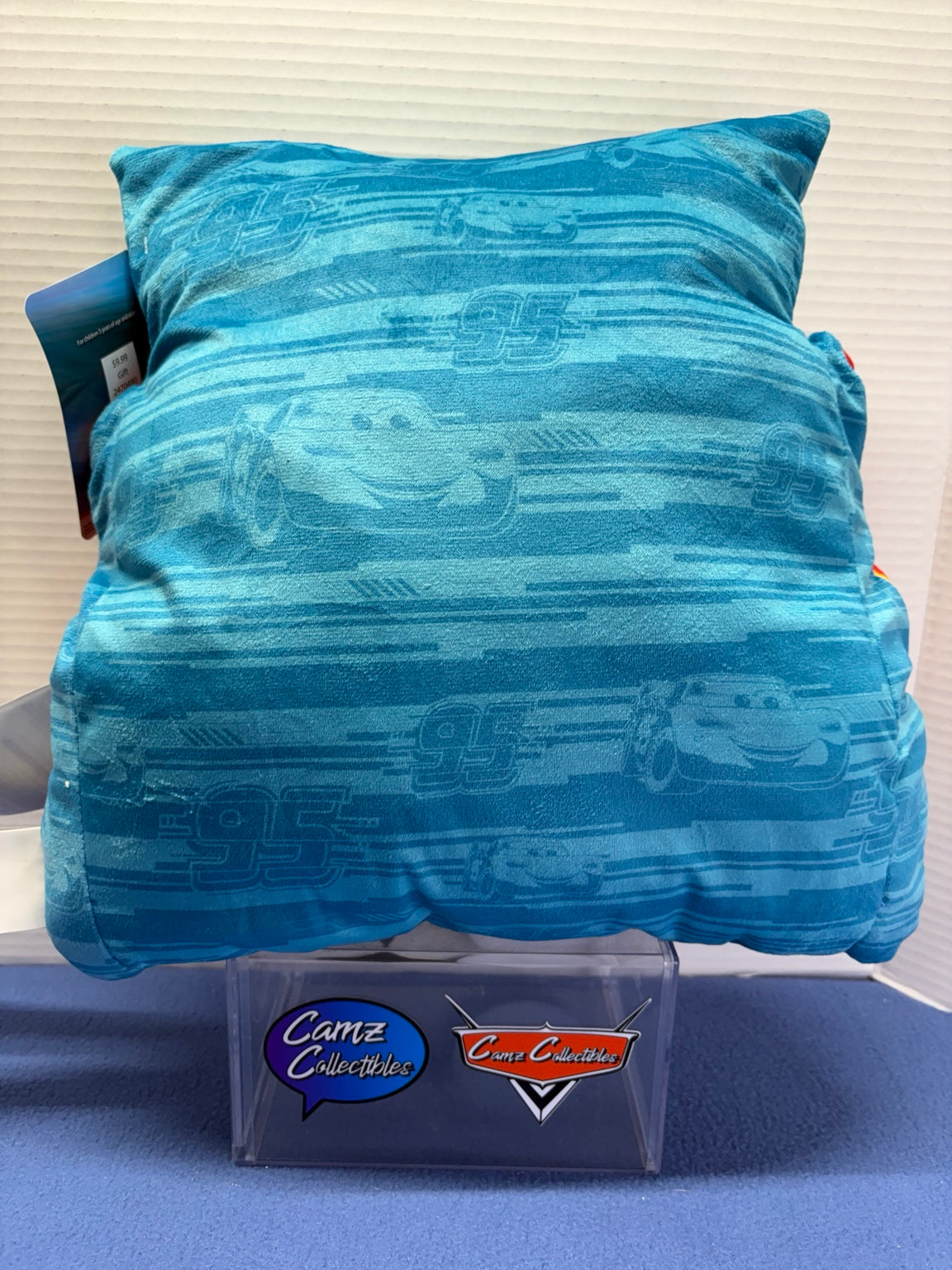 Blue back of Lightning McQueen pillow with McQueen faces, number 95 and racing stripe pattern