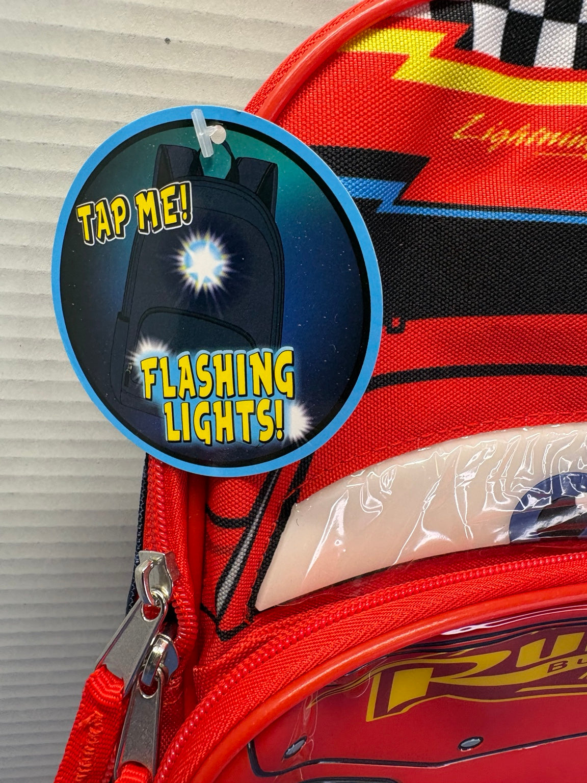 Backpack hangtag reading Tap Me Flashing Lights