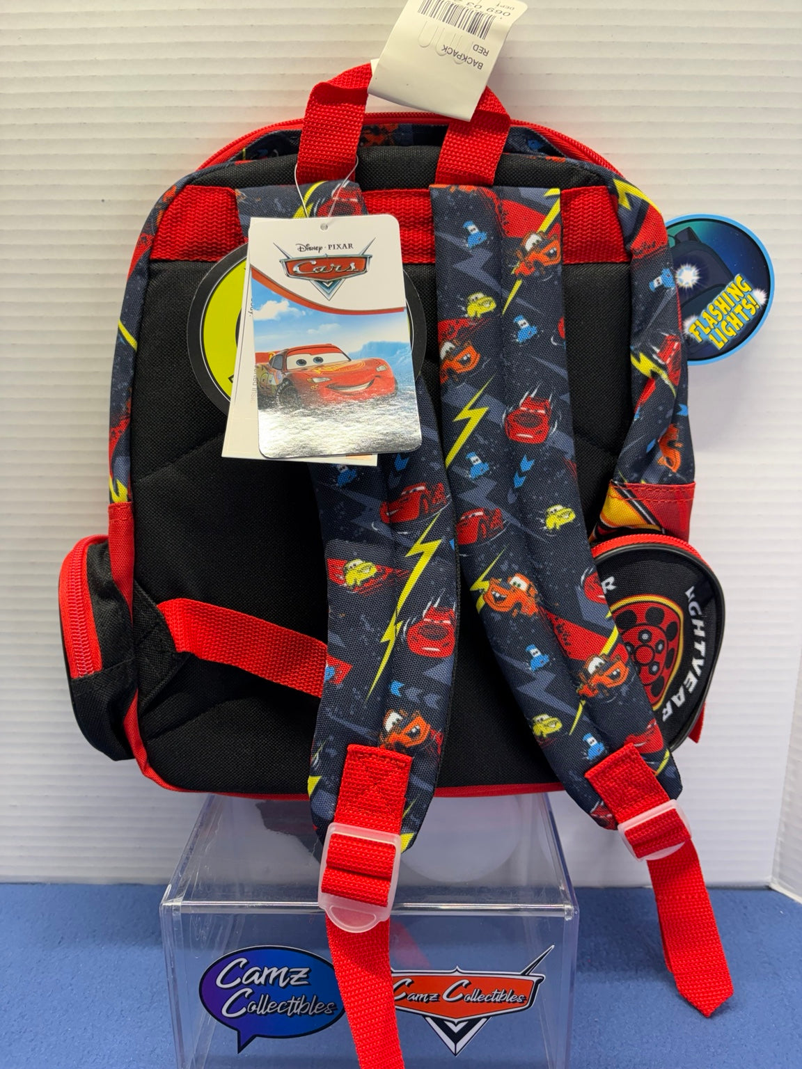 Rear of Lightning McQueen backpack with adjustable printed shoulder straps, carry handle and zippered side pockets