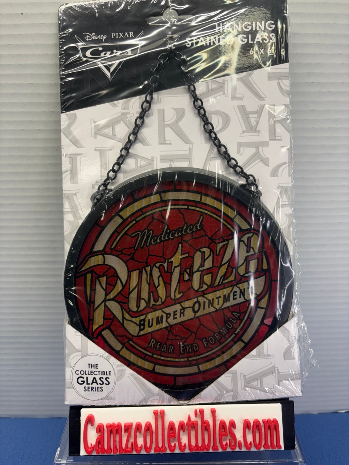 Disney Pixar Cars Rust-eze hanging stained glass with red and gold logo design, black border and hanging chain