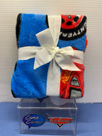 Reverse view of folded blue Lightning McQueen travel blanket tied with white ribbon