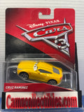 Yellow Disney Pixar Cars 3 Cruz Ramirez in red and black packaging with clear tape above the blister